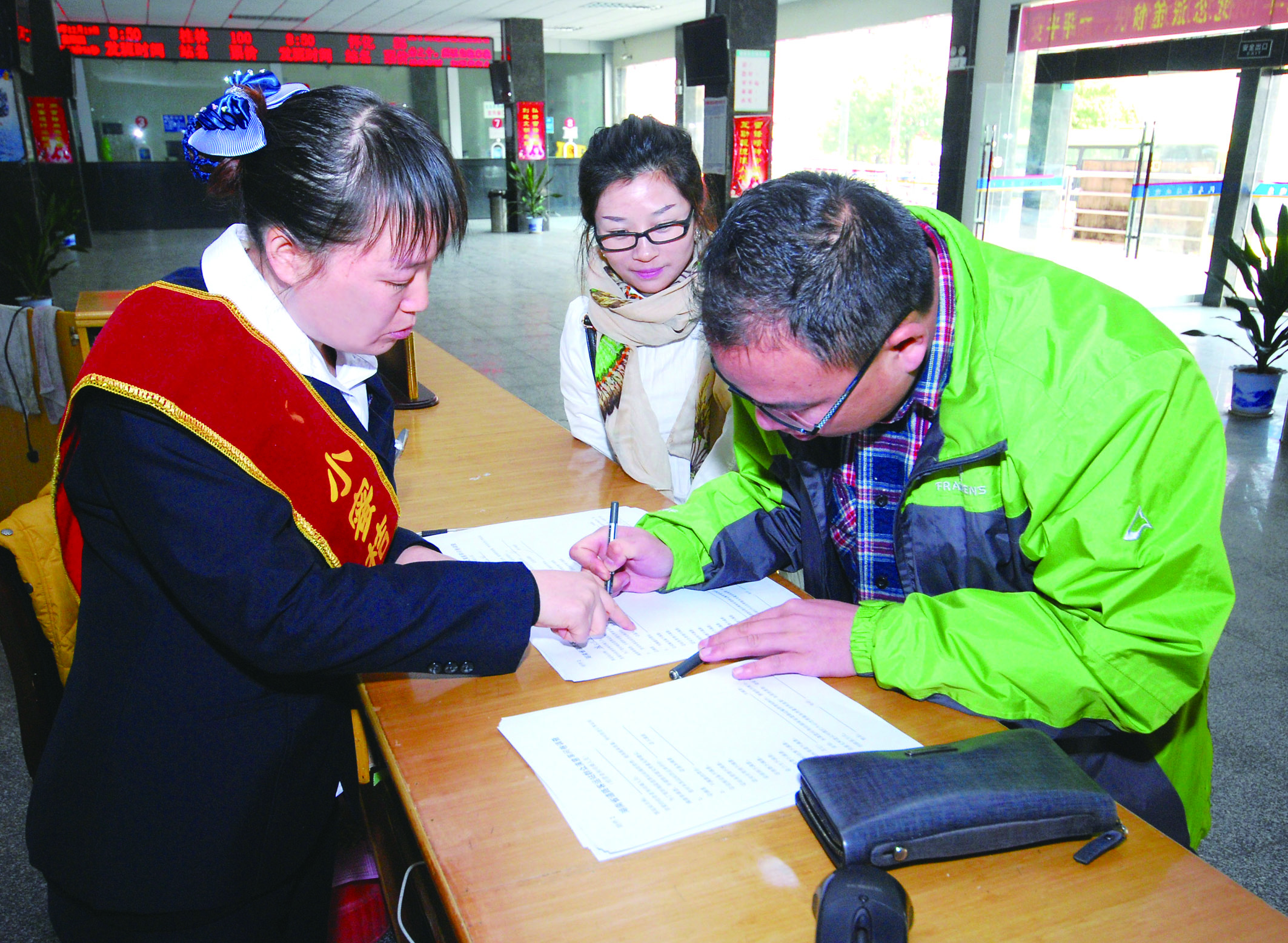 圖為洞口汽車(chē)總站站務(wù)人員在熱心為旅客服務(wù)。